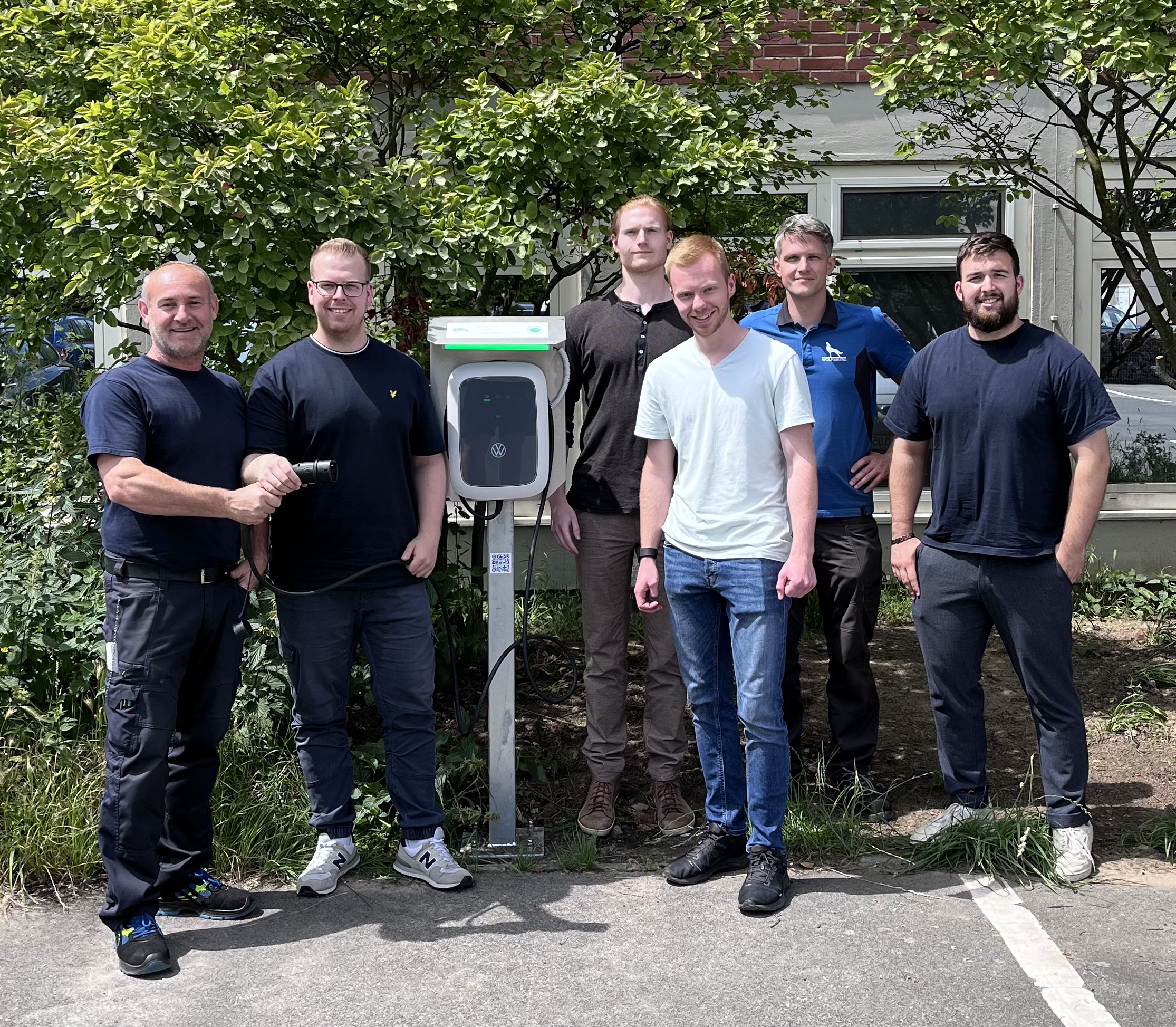 Gruppenfoto des Projektteams gemeinsam mit Sven und Viktor an den fertigen Ladestationen